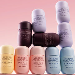 NAK Hair assortment with pink Nourish Shampoo bottles and other travel-size formulas
