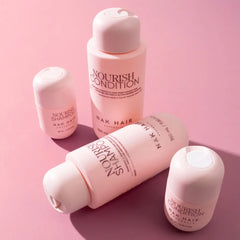 Travel-size Nourish Shampoo and Nourish Conditioner bottles with white caps, pink labels