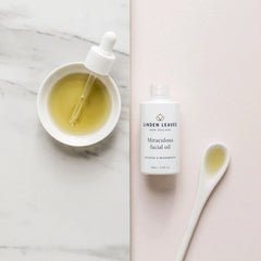 Facial oil bottle with dropper beside small bowl of pale yellow oil