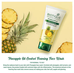 Pineapple oil control foaming face wash tube beside pineapple slices and leaves