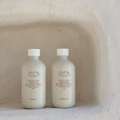 Two Colour Angel bottles with white caps, including a beige shampoo bottle with label
