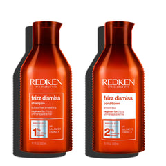 Redken Frizz Dismiss shampoo and conditioner bottles, red with REDKEN labels