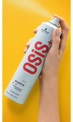 Elastic hairspray bottle with grey cap, held in hand