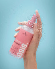 Hairbody bodifying spray bottle with pink mist near wet hand