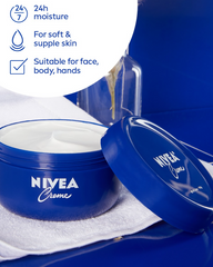 Blue NIVEA Creme jar with open lid and cream on a white towel