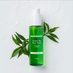 Green Tea face toner bottle with white pump cap, shown with green leaves