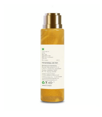 Body oil bottle with metallic cap and white ingredient panel on back