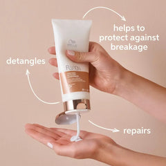 Hair conditioner tube in hand with white body and rose-gold base, dispensing foam