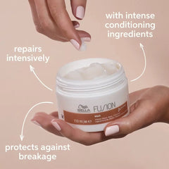 Hair repair mask jar with white cream and rose-gold lid, held in hands