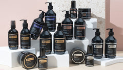 Argan oil gift set display with assorted dark bottles and jars on white risers
