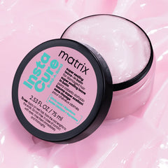 Pink hair balm jar with black lid and teal-and-white label