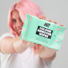 Crazy Color color remover wipe pouch held in hand, green with black label