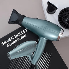 Teal hair dryer with nozzle and heating tool on black mat