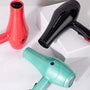 Aqua hair dryer with black concentrator nozzle and cord, with red dryer behind