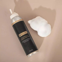 Hair mousse bottle beside a white foam dollop