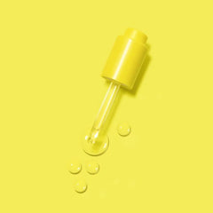 Hair oil dropper with clear oil droplets and yellow cap