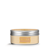 Kama Ayurveda body butter jar with ribbed silver lid and gold diamond pattern label