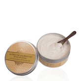 Kokum almond body butter jar with open lid, white cream and wooden scoop
