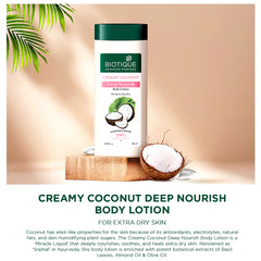 Body lotion bottle with green cap, coconut halves and leaf sprigs