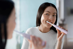 Person using a toothbrush with bristles, Sugar Rose handle