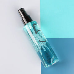 Sea salt spray bottle with black mist pump and teal liquid in clear plastic