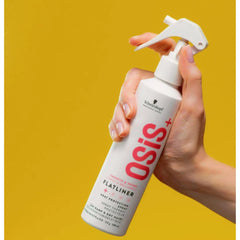 Heat protection spray bottle with white trigger nozzle held in hand