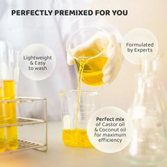 Hair oil bottle with golden oil being poured into a glass beaker