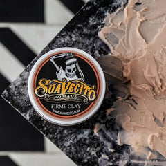 Clay pomade jar with circular label and skull graphic, shown from front-left angle