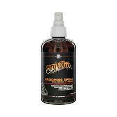 Grooming spray bottle with pump, dark amber liquid, labeled transparent plastic