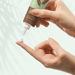 Under-eye gel dispensed onto finger from a squeeze tube nozzle