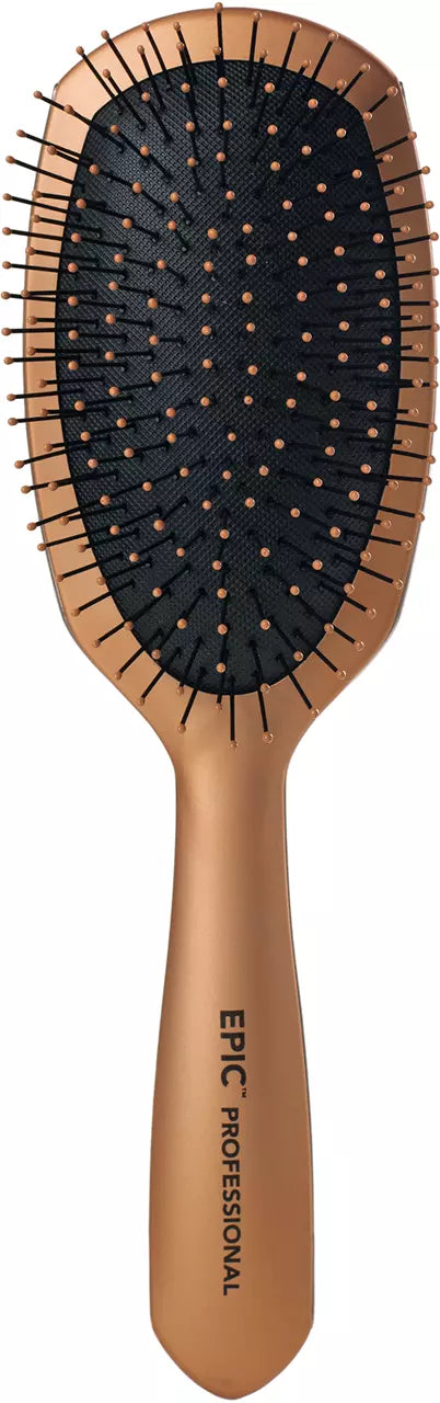 Paddle hair brush with dark bristle pins and tan handle, ergonomic grip.