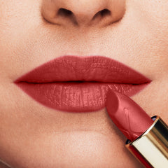 Red Moisture Kiss lipstick on lips with gold-capped applicator