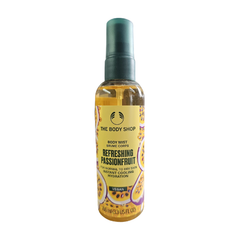 The Body Shop passionfruit body mist bottle with spray nozzle, amber liquid, 100 ml