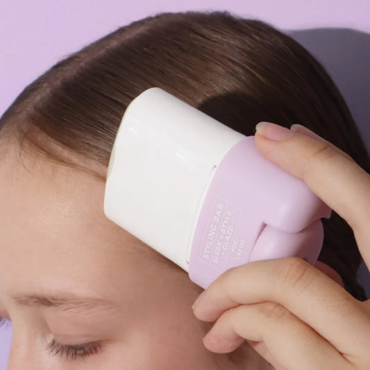Lavender hair styling bar held near dark hair; label faces camera