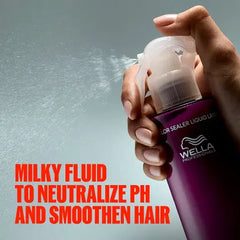 Hand holding Wella Ultimate Color leave-in sealer spray bottle; purple liquid