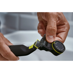 Hand using electric OneBlade trimmer on stubble with adjustable guard