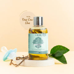 Baby massage oil bottle with silver cap, amber oil, teal label with leaf and spoon