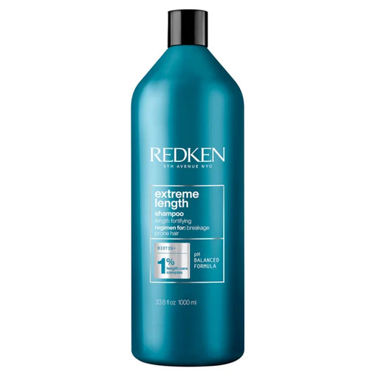 Redken shampoo bottle with teal body and black pump cap, label text visible.