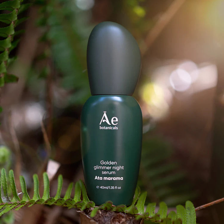 Green night serum bottle standing outdoors, Ae botanicals label