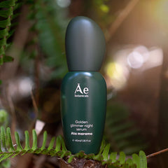 Green night serum bottle standing outdoors, Ae botanicals label