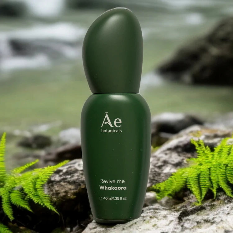 Dark green Ae botanicals serum bottle with rounded cap on rocks and moss