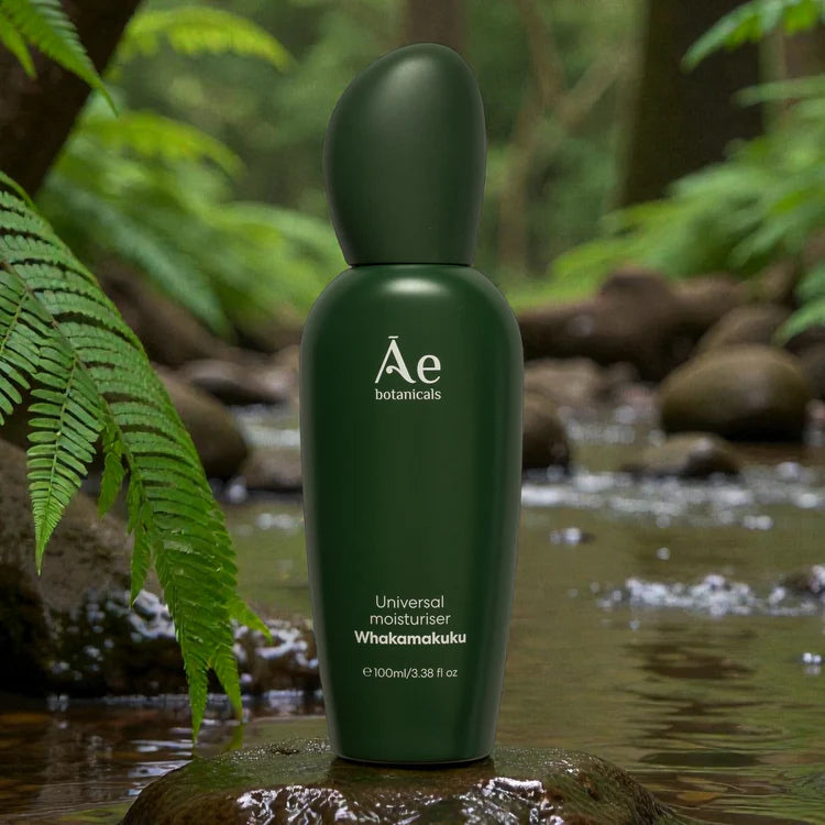 Ae Botanicals Universal Moisturiser 100ml green bottle standing on a wet surface