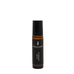 Perfume oil bottle with black cap, dark label, and amber band at center