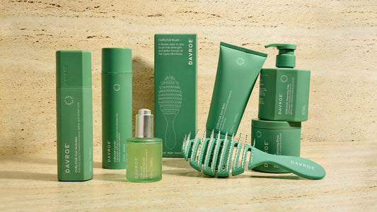 Davroe CURLiCUE hair care products set with green bottles, tubes, and brush