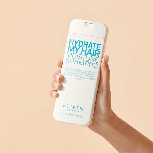 Eleven Australia Hydrate My Hair Moisture Shampoo bottle held in hand, front label