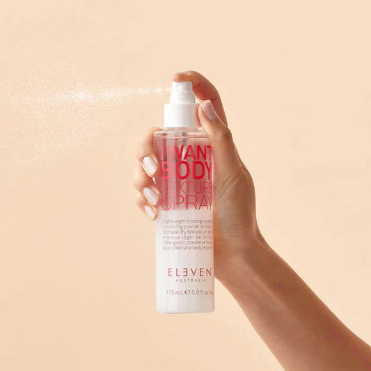 Body texture spray bottle in hand with white pump dispensing mist