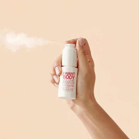 Hand holding body volume powder bottle with clear cap