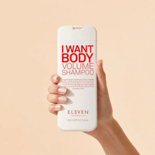 Body volume shampoo bottle held in hand, cream and red label, 300 ml