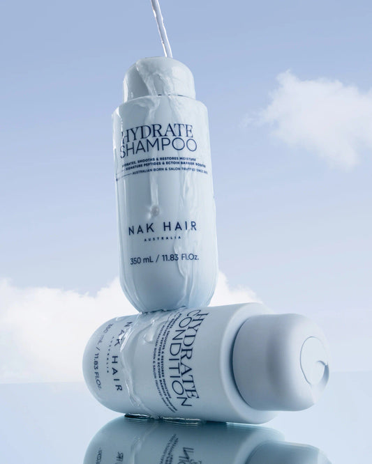 Nak Hydrate Shampoo and Hydrate Conditioner bottles, light blue, for hair hydration