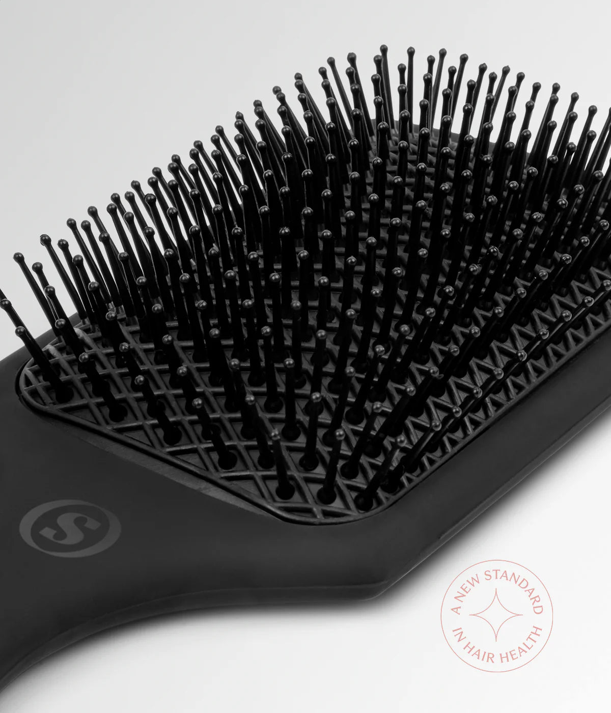 Black cushion hair brush with curved edge and pin-filled cushion pad